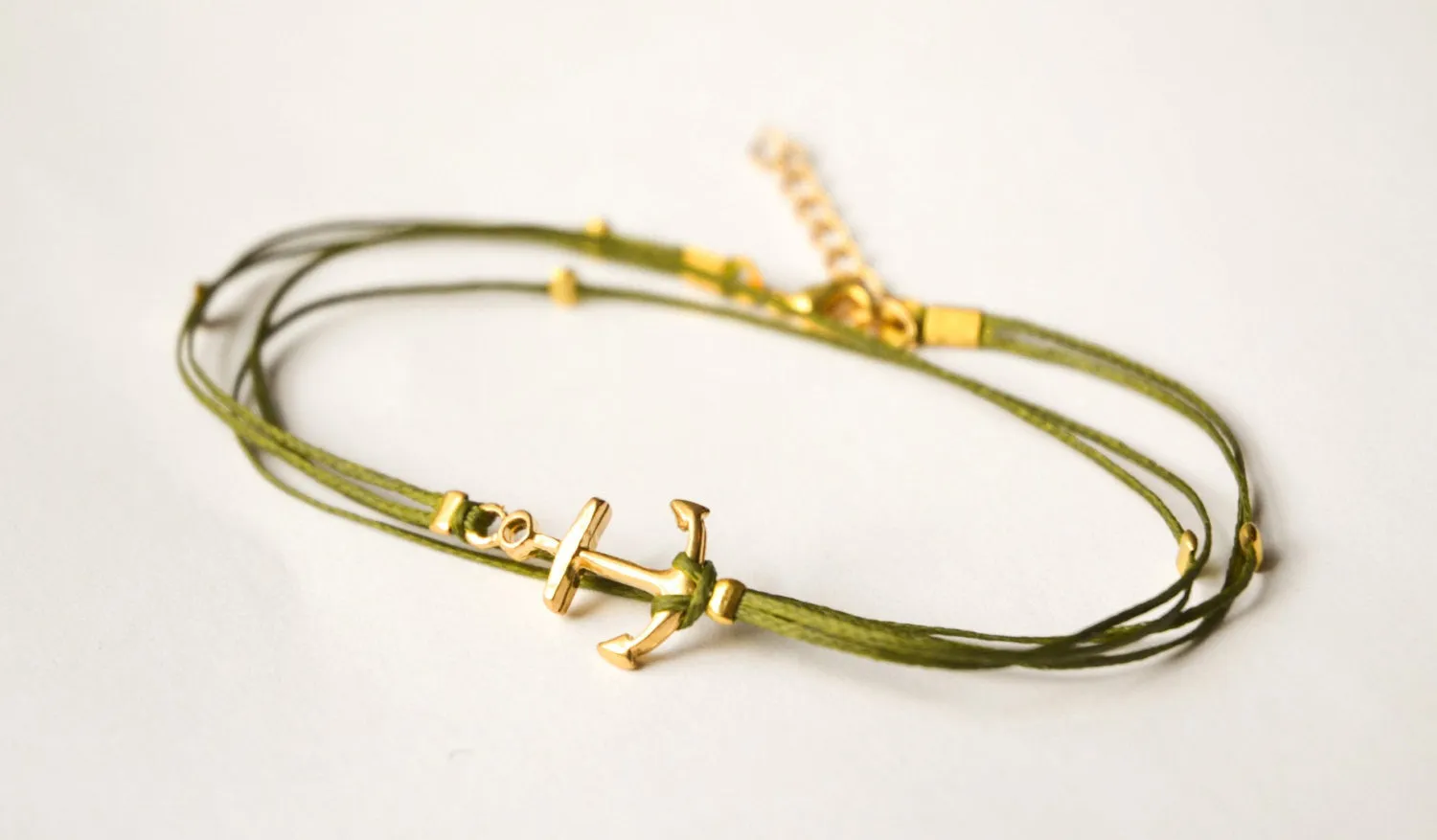 Handmade green dainty anklet with a gold anchor charm and gold beads